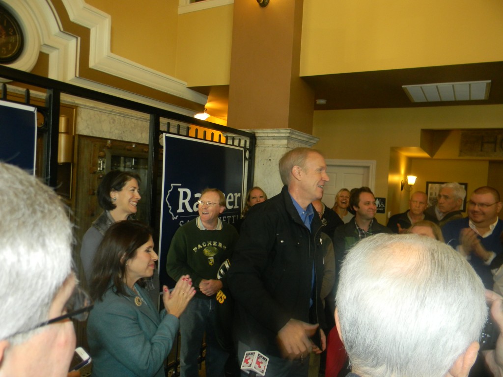 Newly elected governor Bruce Rauner, flanked by his wife Diana (in back) and Lt. Governor-elect Evelyn  Sanguinetti were greeted by a large crowd at the Vault Cafe in Marion on Friday morning. 