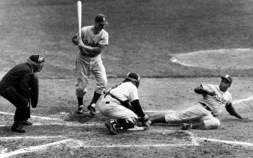 On this Sept. 28, 1955, the  Brooklyn Dodgers' Jackie Robinson stole home under the tag of New York Yankees catcher Yogi Berra in the eighth inning of the World Series opener at New York's Yankee Stadium. (AP Photo/John Rooney, File)